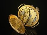 an image of a gold pocket watch sitting on top of a black surface