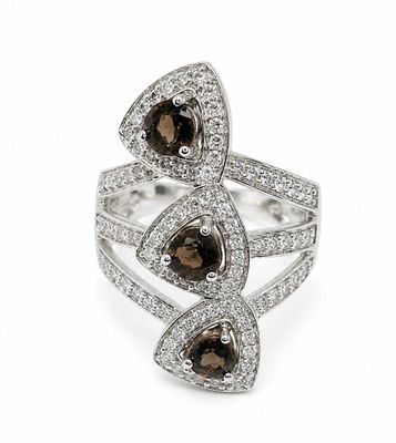 a close up of a ring with two brown and white diamonds