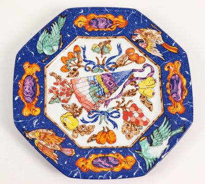 une image représentant une assiette bleue et orange ornée d'oiseaux et de fleurs
