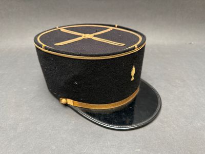 un chapeau noir orné d'un ruban doré sur le dessus