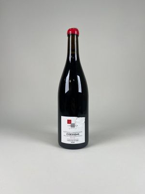 une bouteille de vin rouge posée sur une table blanche