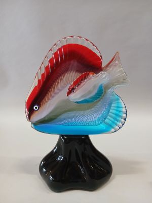 un poisson rouge et blanc posé sur un socle noir