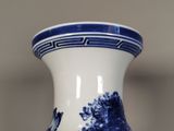 a blue and white vase sitting on top of a table