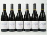 six bouteilles de vin rouge sont alignées sur une table