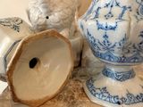 a blue and white vase sitting on a shelf next to a white elephant