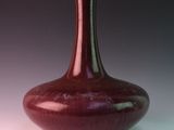 a red vase that is sitting on a table