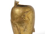 gold vase with a bird on top of it on a white surface