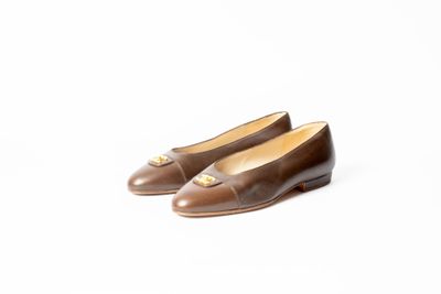 une paire de chaussures marron sur fond blanc
