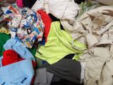 a pile of clothes sitting on the floor next to a bed
