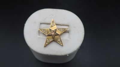 an image of a gold star ring sitting on top of a white box