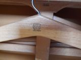 a close up of a wooden coat rack with a wooden hanger