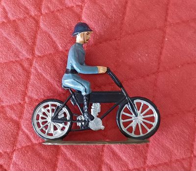 une figurine représentant un homme à moto, assis sur une couverture rouge
