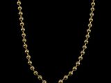 un collier en or avec une chaîne à maillons ronds sur fond noir