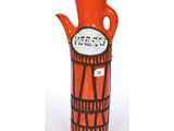un vase rouge orné d'un motif en noir et blanc