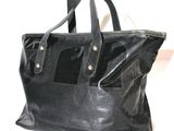 sac fourre-tout en cuir noir sur fond blanc, avec un texte stylisé en flux continu