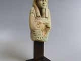 an egyptian statue of a man with a head on a wooden stand