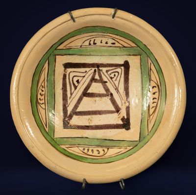 une assiette verte et blanche sur laquelle figure un triangle