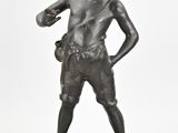 statue en bronze représentant un garçon portant un gant à la main