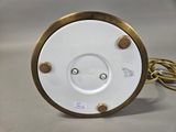 a close up of a white and gold clock on a table