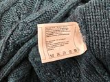 a label on the back of a blue sweater