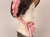 an image of a mannequin head wearing a pink and black hat