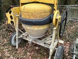 a cement mixer sitting in the middle of a field
