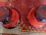 two bottles of soda sitting on a rug on the floor