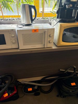 two microwaves and a coffee maker on the counter