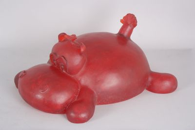 un cochon rouge couché sur une surface blanche