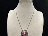 a close up of a necklace on a mannequin with a black background