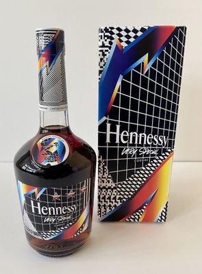 the bottle of henness is next to the box on the table