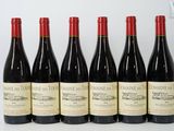 six bouteilles de vin rouge sont alignées sur une table