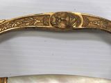 a gold plated handle with a white marble handle