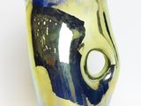 a close up of a blue and yellow vase with a hole in it