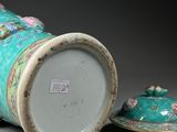 a blue vase with a lid sitting next to another vase