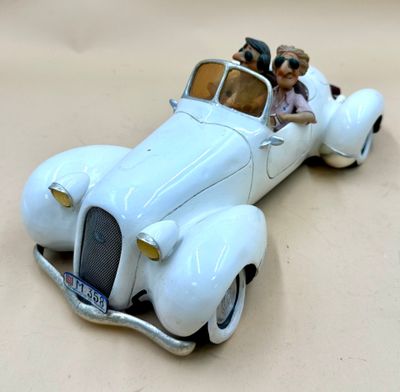 a toy car with two people in it on a table