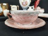 a pink cup and saucer on a black table