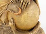 a statue of a woman with a snake on a ball