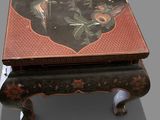 a small table with a black and red design on it