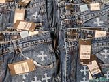 several pairs of jeans with tags on them sitting on a table