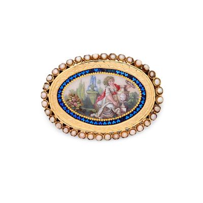 un gros plan d'une broche en or ornée d'une peinture