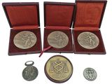 three medals and a keychain are in a wooden case