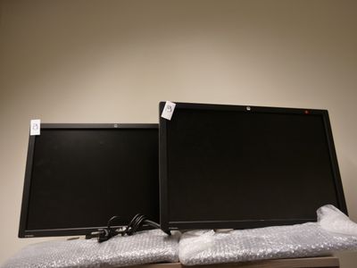 deux écrans d'ordinateur posés sur une table
