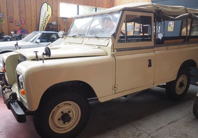 a tan land rover parked in a garage next to other cars
