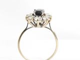 a close up of a black and white diamond ring on a white background