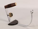 a metal object with a wooden handle on a white surface