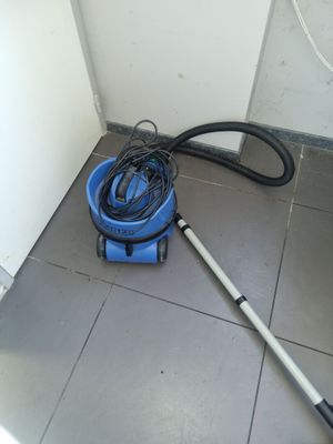 un aspirateur bleu et noir posé par terre à côté d'un seau bleu