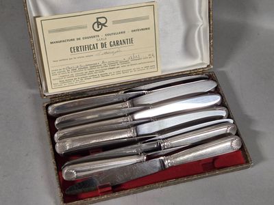five knives in a box that are sitting on a table
