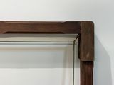 une étagère en verre sur laquelle est posée une horloge, dans une pièce