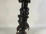 a wooden statue of a woman with a snake on her head